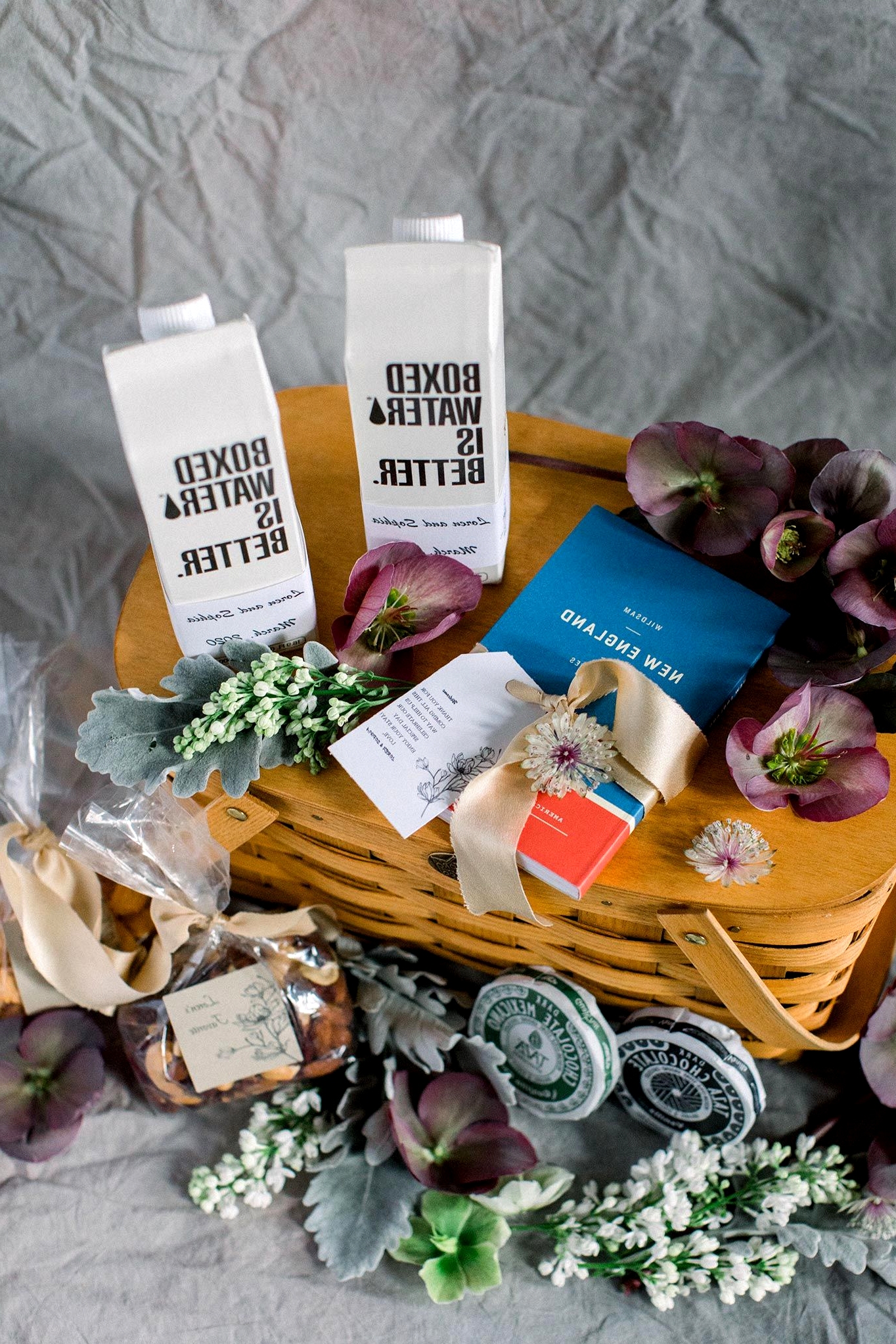 New England wedding welcome basket with boxed water, New England guide, hellebore and more